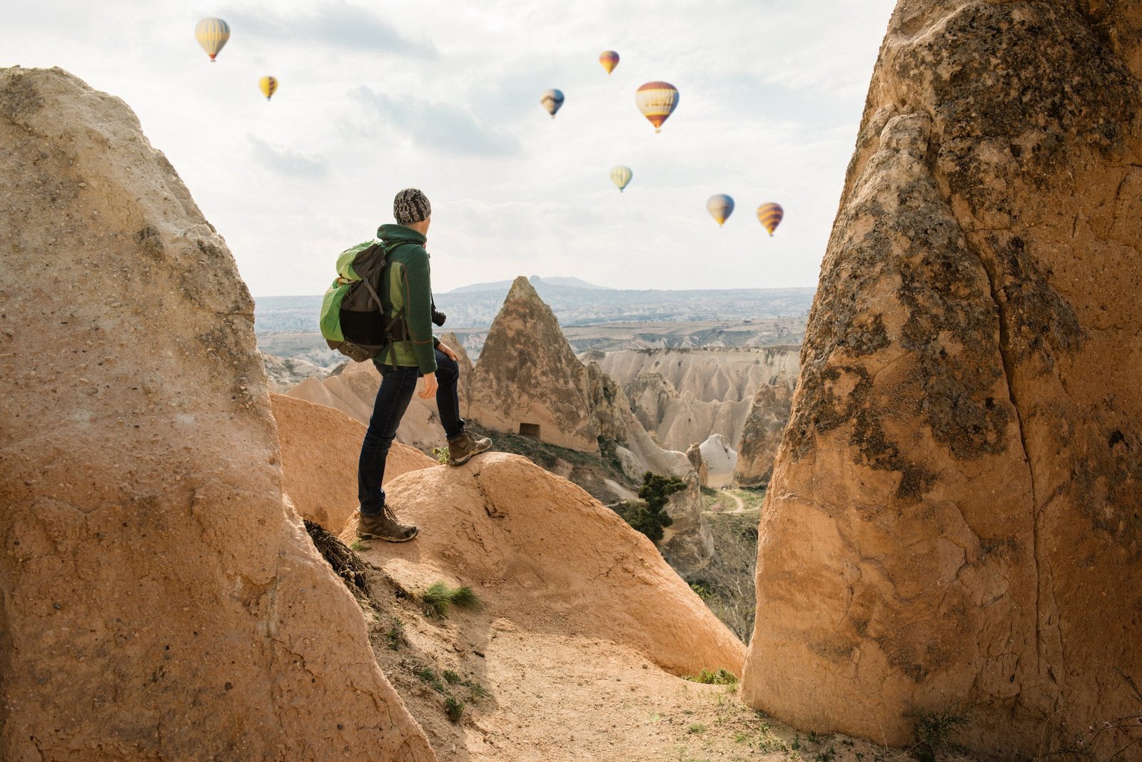 Male tourist exploring Cappadocia Red and Rose valleys. Magic sandstone mountains and cave landscape
